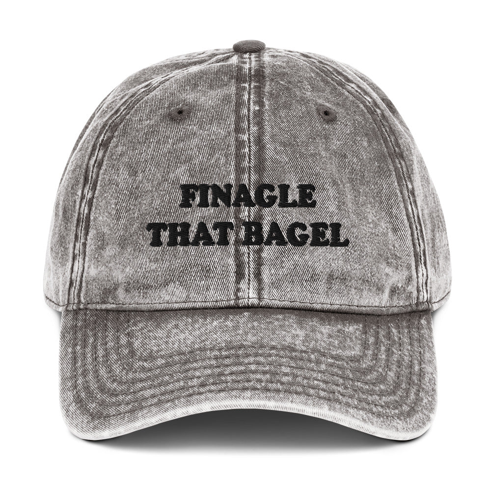 Gray Finagle That Bagel Hat - Love Bagels? Looking for a funny gift for a bagel enthusiast? This Unique Bagel Hat is just what you need. It's comfortable, has an adjustable closure, and comes in a variety of colors with "Finagle That Bagel", on the front. Eat your favorite bagels in this funny food dad hat. Perfect for bagel lovers and beyond.