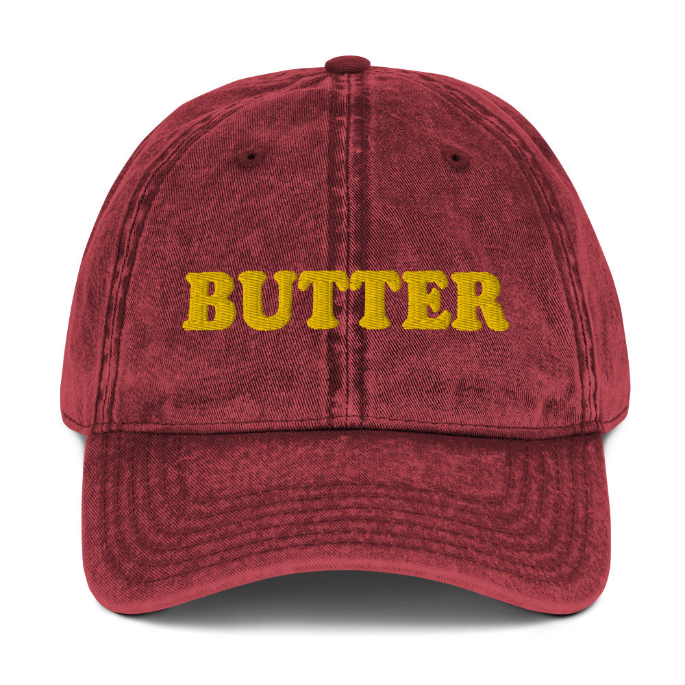 Maroon Butter Dad Hat - Do you love butter? This butter hat is just what you need. It's comfortable, has an adjustable closure, and comes in a variety of colors with "butter", expertly embroidered on the front. Add a little personality to your everyday style with this funny foodie hat. Perfect for butter lovers and beyond. Celebrate your favorite foods in our funky foodie clothing and accessories.