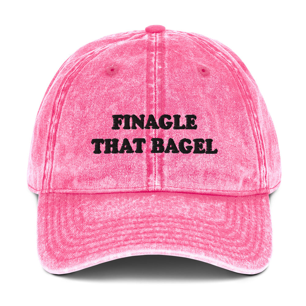 Pink Finagle That Bagel Hat - Love Bagels? Looking for a funny gift for a bagel enthusiast? This Unique Bagel Hat is just what you need. It's comfortable, has an adjustable closure, and comes in a variety of colors with "Finagle That Bagel", on the front. Eat your favorite bagels in this funny food dad hat. Perfect for bagel lovers and beyond.